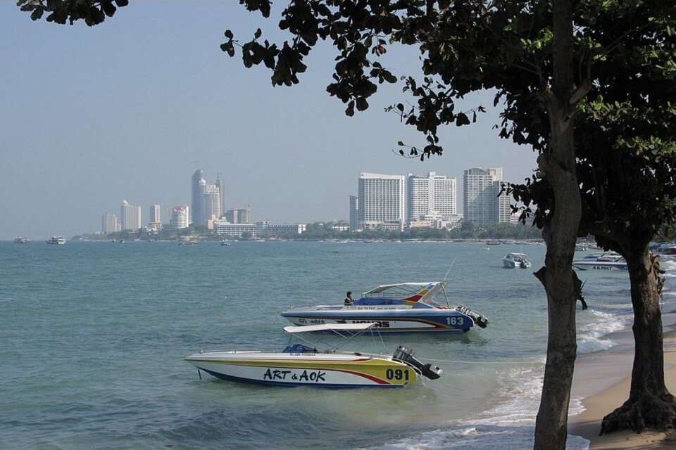 Speedboats beside Pattaya Beach with the city skyline across the bay