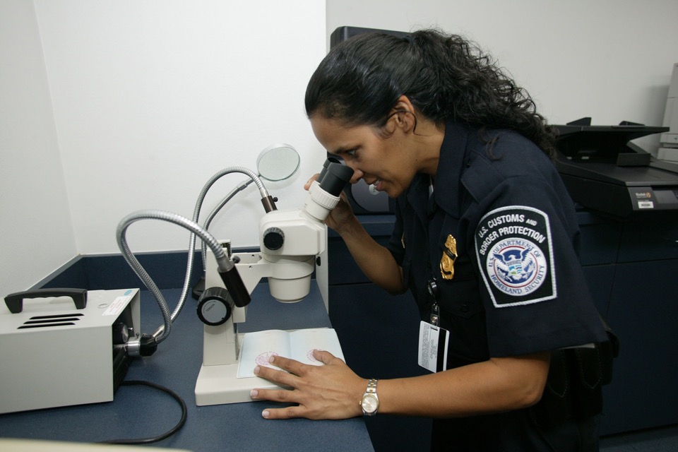 Travel-document specialist checking a document for authenticity