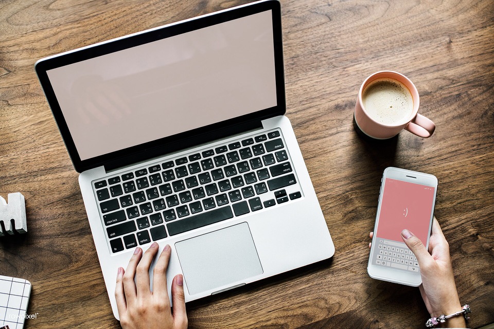 Travel coordinator working with a laptop and smartphone
