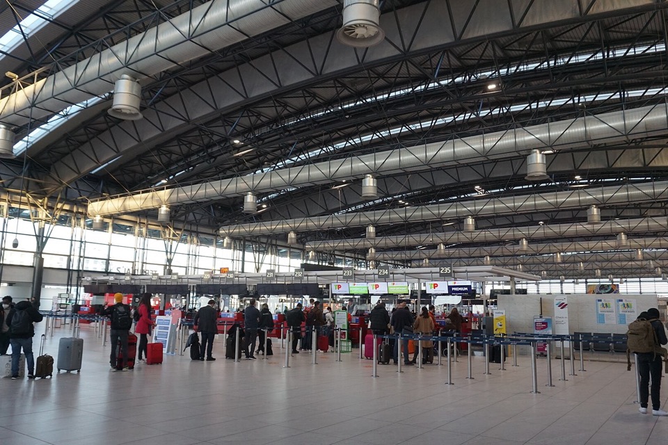 Travellers queuing at airport check-in counters