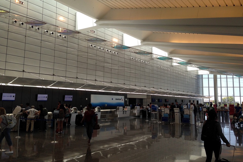 Airline check-in counters inside a bright airport terminal