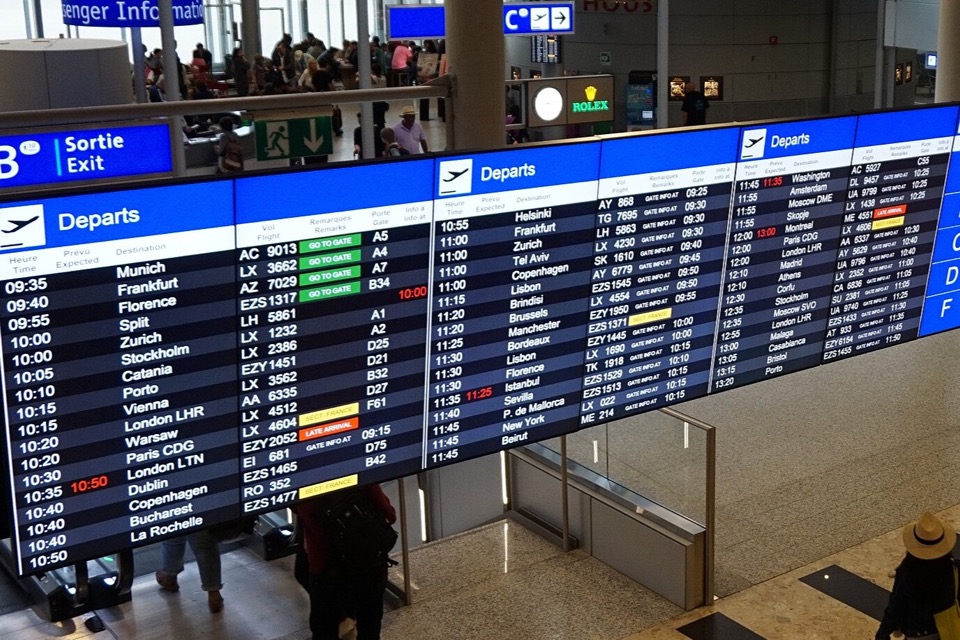 Airport departure board showing flights to multiple destinations