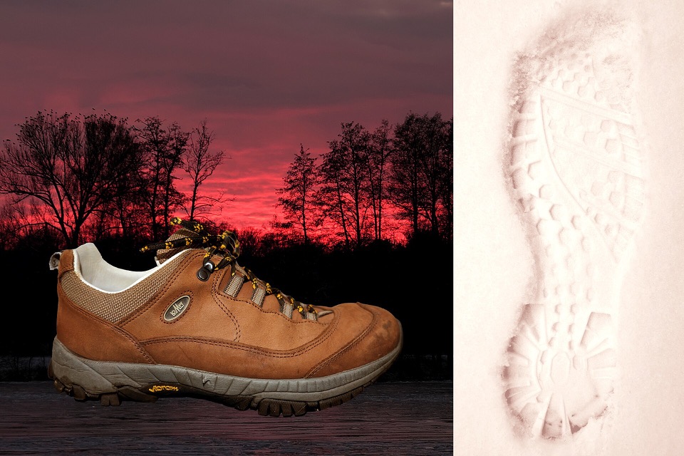 Hiking boots and fresh footprints in snow
