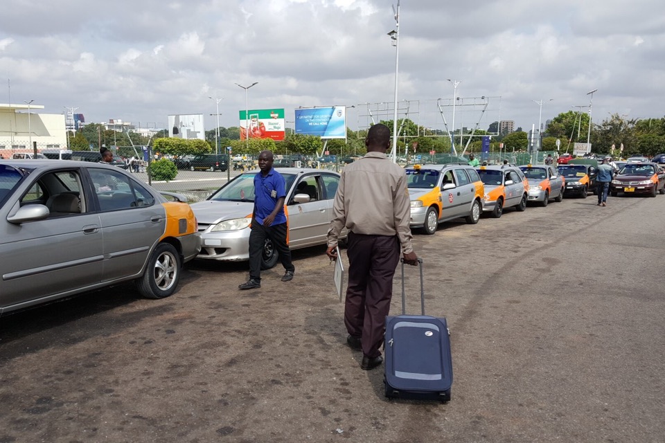 Airport shuttle driver helping a passenger with luggage